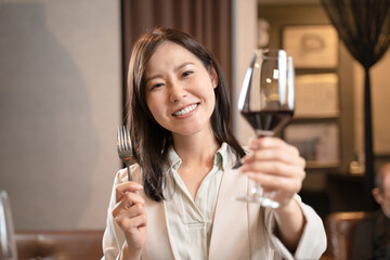 飲食店で赤ワインで乾杯をする女性