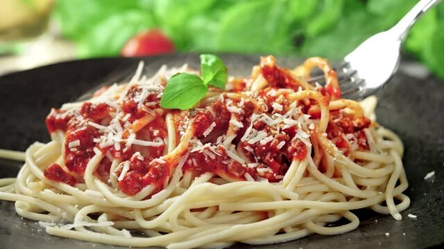 Spaghetti Bolognese Served on Black Plate Wrapped on Silver Fork in Slow Motion
