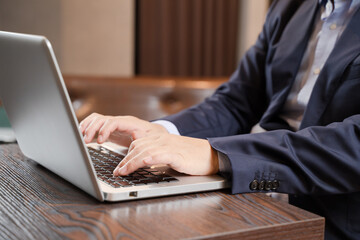 カフェでリモートワークをする男性ビジネスマンの手元