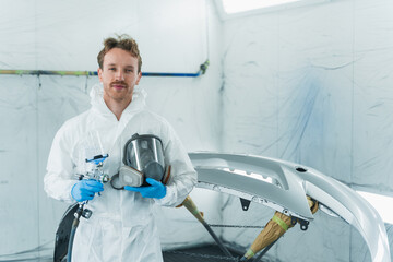 Portrait of a young car painter in a auto painting booth