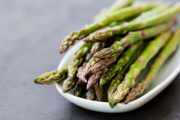 Close up asparagus spears over dark background with copy space. Healthy, vegan food concept. Clean eating.
