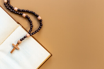Old Bible book and rosary beads with cross. Christian religion concept