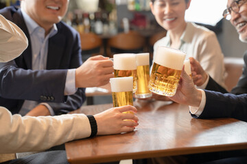 ビールで乾杯する会社帰りの打ち上げ飲み会手元