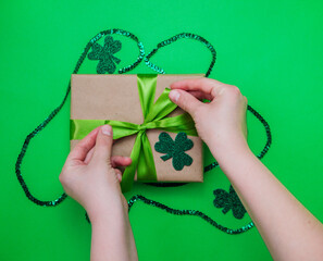 Happy March 17th. St. Patrick's Day.Top view from above, a gift box wrapped in kraft paper, clover...