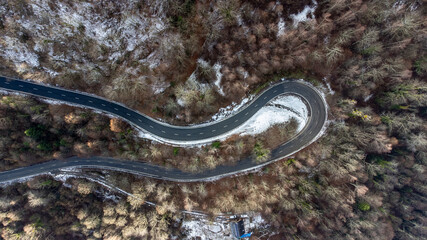 Aerial view of the road between the pines. winter landscape in the mountains