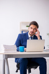 Young male employee and too much work in the office