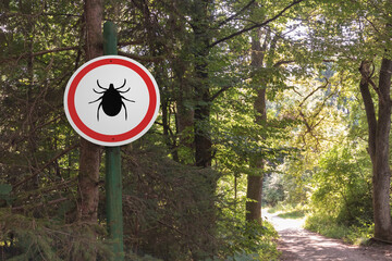 Warning sign beware of ticks in infested area in the forest.