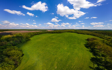 Aerial landscape view of green cultivated agricultural fields with growing crops on bright summer day