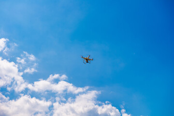 Naklejka na ściany i meble Flying drone in the blue sky. Technology concept.