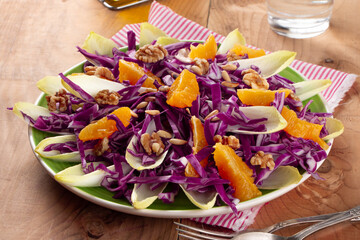 Colorful red cabbage salad with endive and orange fruit