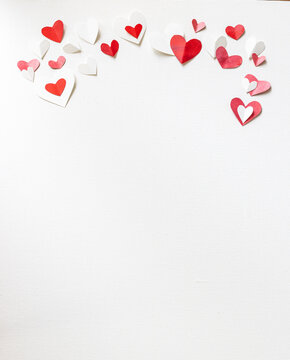 Valentines Day or wedding, invitation, scattered painted small cut out red, pink and white hearts vertical with copy space