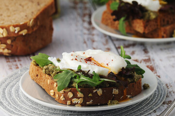 Homemade sandwiches with pesto, green salad and poached eggs	