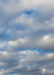 White fluffy clouds densely cover the blue sky