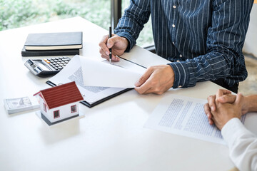 Real estate broker agent being analysis and making the decision a home estate loan to customer to signing contract documents for realty purchase, Bank employees recommend mortgage loan approval