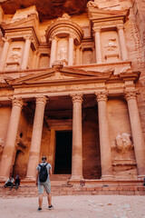 Tourist with a backpack in front of the Treasury in Petra, Jordan