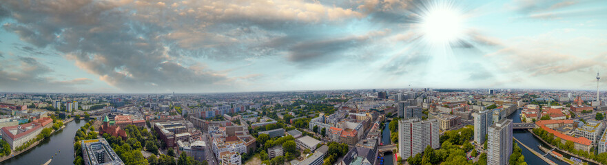 Fototapeta na wymiar Panoramic aerial view of Berlin skyline at sunset with major city landmarks along Spree river, Germany from drone in summer season.