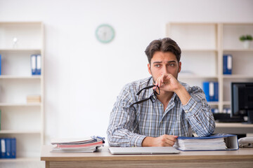 Young male employee sitting in the office