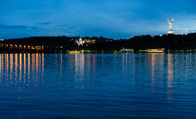 Obraz premium View of Mother Motherland monument above Dnipro river with Paton bridge and Kiev city at sunset, Ukraine.