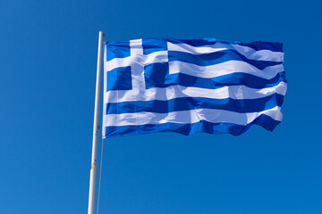 Greek national flag againts blue sky
