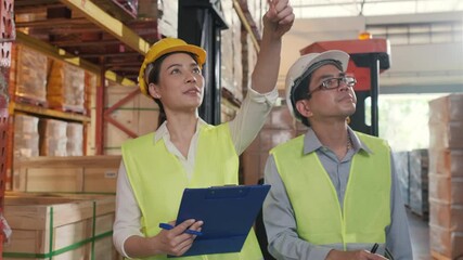 Asian factory manager and engineer woman working in warehouse. Warehouse worker talking about storage department controlling logistic distribution to the market. - Powered by Adobe