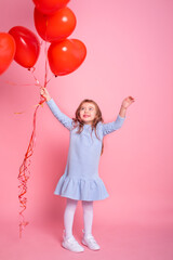 Obraz na płótnie Canvas Beautiful child girl with red heart romantic balloons on pink background. Concept of Valentine day