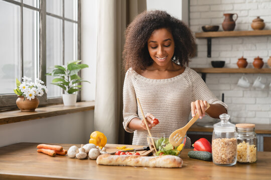 Vegan Vegetarian Food Meal Concept. Dieting And Healthy Eating Habits. African Woman Girl Cooking Vegetable Salad At Home Kitchen