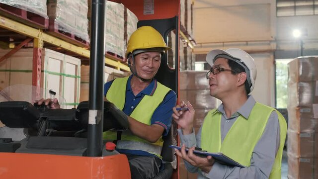 Supervisor Asian man order the forklift driver for work at the warehouse.