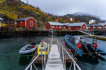 Boats moored in sea in coastal town on foggy day