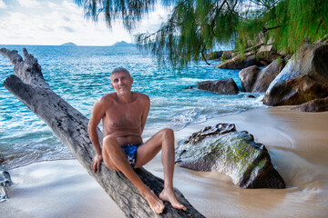 Man relaxing on a tropical tree trunk.
