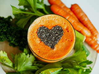 bird view of a glass with healthy cold pressed carrot orange juice and chia seeds on top in form of...