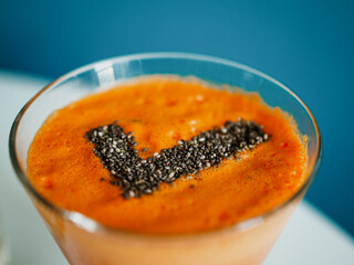 bird view of a glass with healthy cold pressed carrot apple juice and chia seeds on top in the form of a checkmark for a successfully completed juicing detox fast