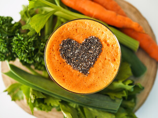 bird view of a glass with healthy cold pressed carrot orange juice and chia seeds on top in form of...