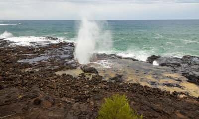 Fototapeta na wymiar Spouting Horn Park on Kauai Island, Hawaii. Water being sprayed out of the Spouting Horn an old volcanic lava tube