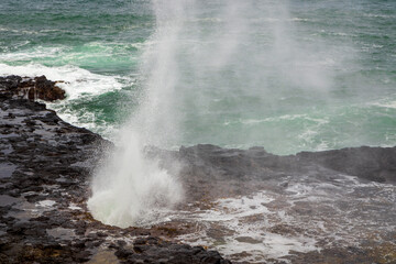 Spouting Horn Park on Kauai Island, Hawaii. Water being sprayed out of the Spouting Horn an old volcanic lava tube