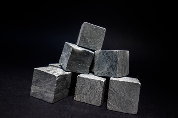  Stones for cooling drinks in the form of a pyramid stand on a dark background. Stones for whiskey. High quality photo