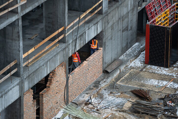 aerial top view of city construction site. tower cranes for building of new apartments under snow in winter