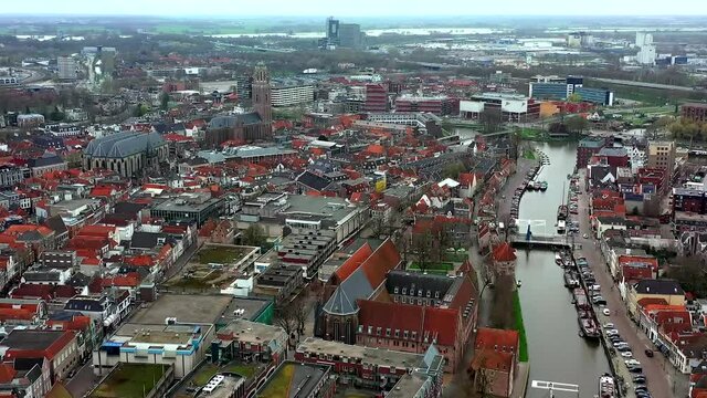 Aerial top view of a city in Holland, surrounded by houses, green trees and canal