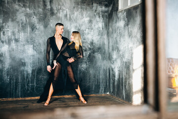 Couple of two professional ballroom dancers is dancing on loft studio. Beautiful art performance....