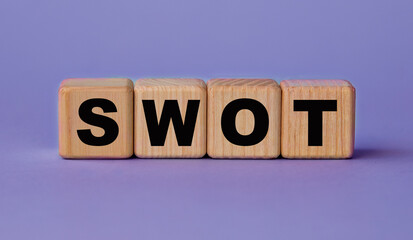 SWOT - acronym on wooden cubes on a lilac background