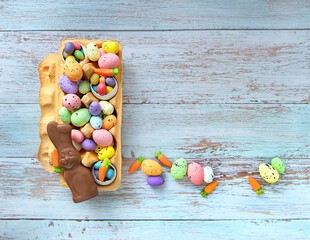 chocolate Easter bunny and sweet eggs, candies, marmalade carrots in box on table. Easter Holiday. seasonal festive spring gift box. Flat lay	