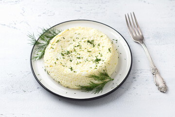 Delicious diet steam omelet on a white plate, light blue textured background