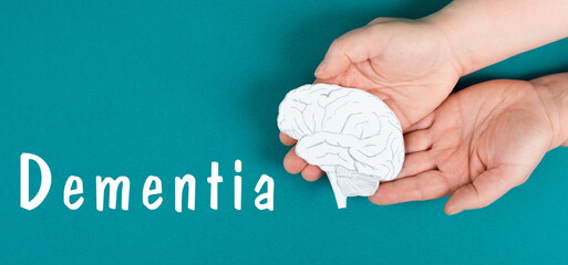 Dementia  is standing on a paper, hands holding brain, disease diagnosis, Alzheimer's illness