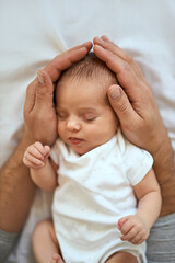 Father holding head of sleeping baby In the safe hands