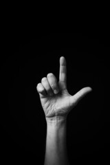 B+W image of hand demonstrating Chinese sign language letter L isolated against black background