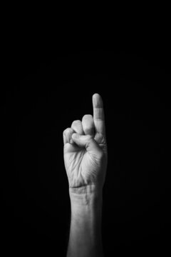 B+W image of hand demonstrating Chinese sign language letter I isolated against black background