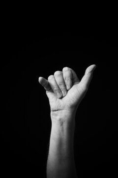 B+W image of hand demonstrating Chinese sign language letter Y isolated against black background