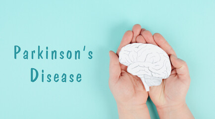 Parkinson's disease is standing on a paper, hands holding brain, dementia diagnosis, Alzheimer's...