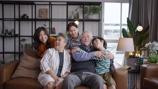 Portrait of happy Asian family spending time together on sofa in living room. family and home concept.