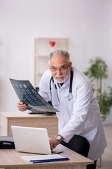 Old male doctor radiologist working in the clinic