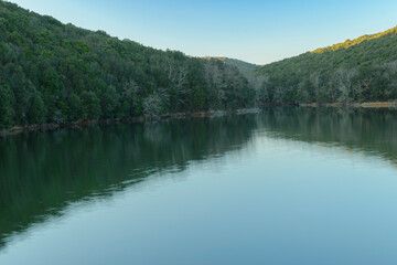 Fototapeta premium Scenic landscape on a sunny day on the lake with the reflection of the trees and the sky in the water. Bicocchi lake, Montioni Natural Park, Tuscany Italy